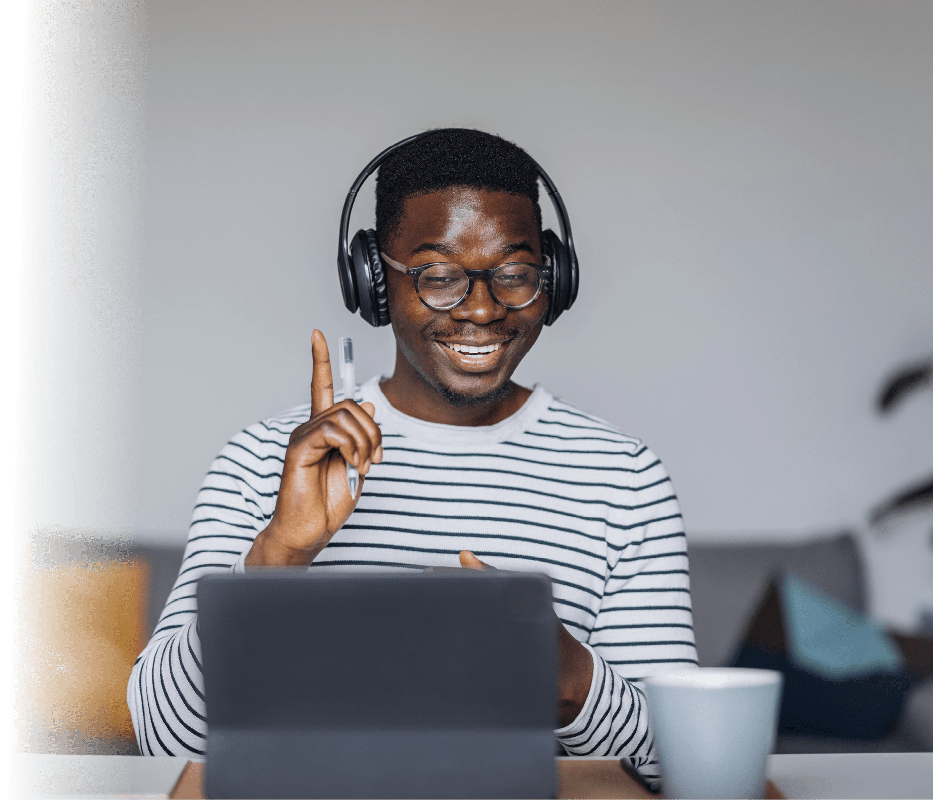 Cheerful African-American man with headphones having online meeting on digital tablet at home office