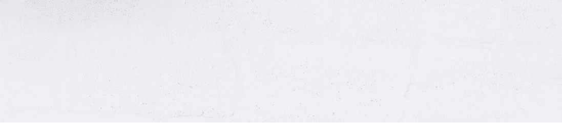 Portrait of smiling man with headphones and cellphone standing by white wall