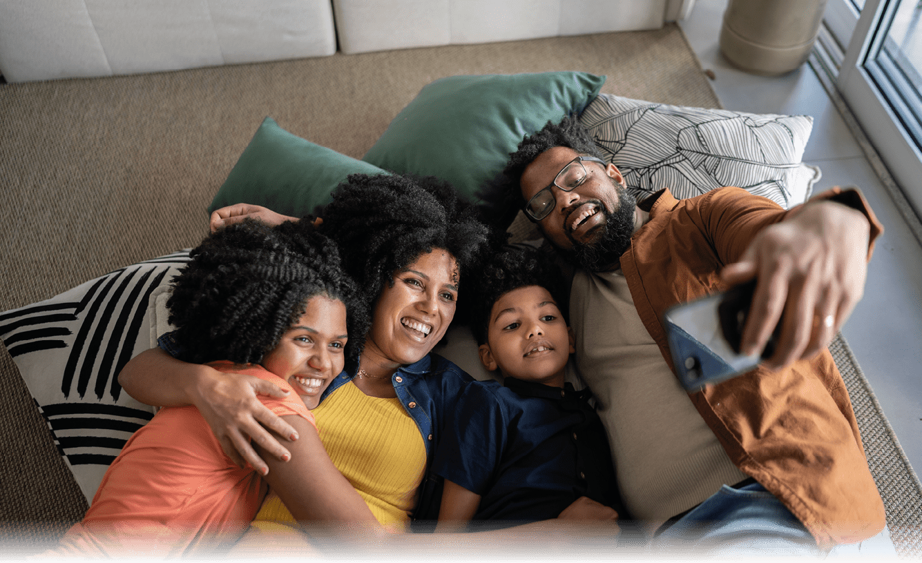 Family using mobile phone lying on the floor at home