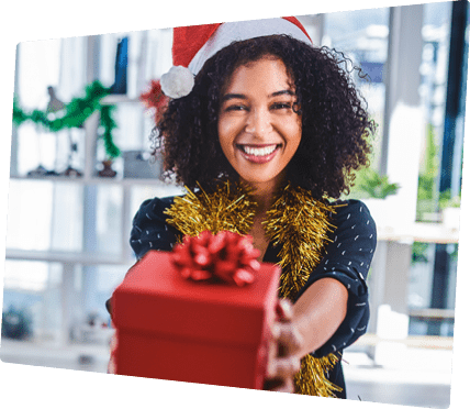 Cropped shot of an attractive young businesswoman sitting alone in the office and holding out a christmas present
