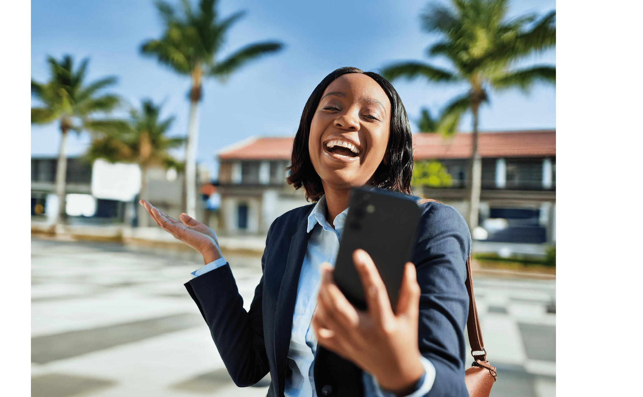 A joyful Black businesswoman dressed in professional attire laughing and holding a smartphone in an urban environment. Ideal for concepts such as business, entrepreneurship, communication, and city life.
