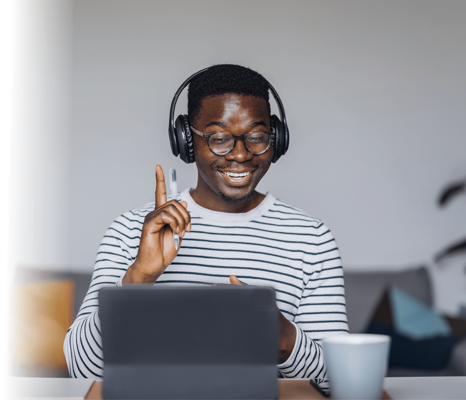Cheerful African-American man with headphones having online meeting on digital tablet at home office
