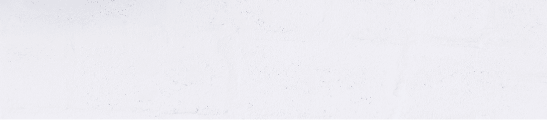 Portrait of smiling man with headphones and cellphone standing by white wall