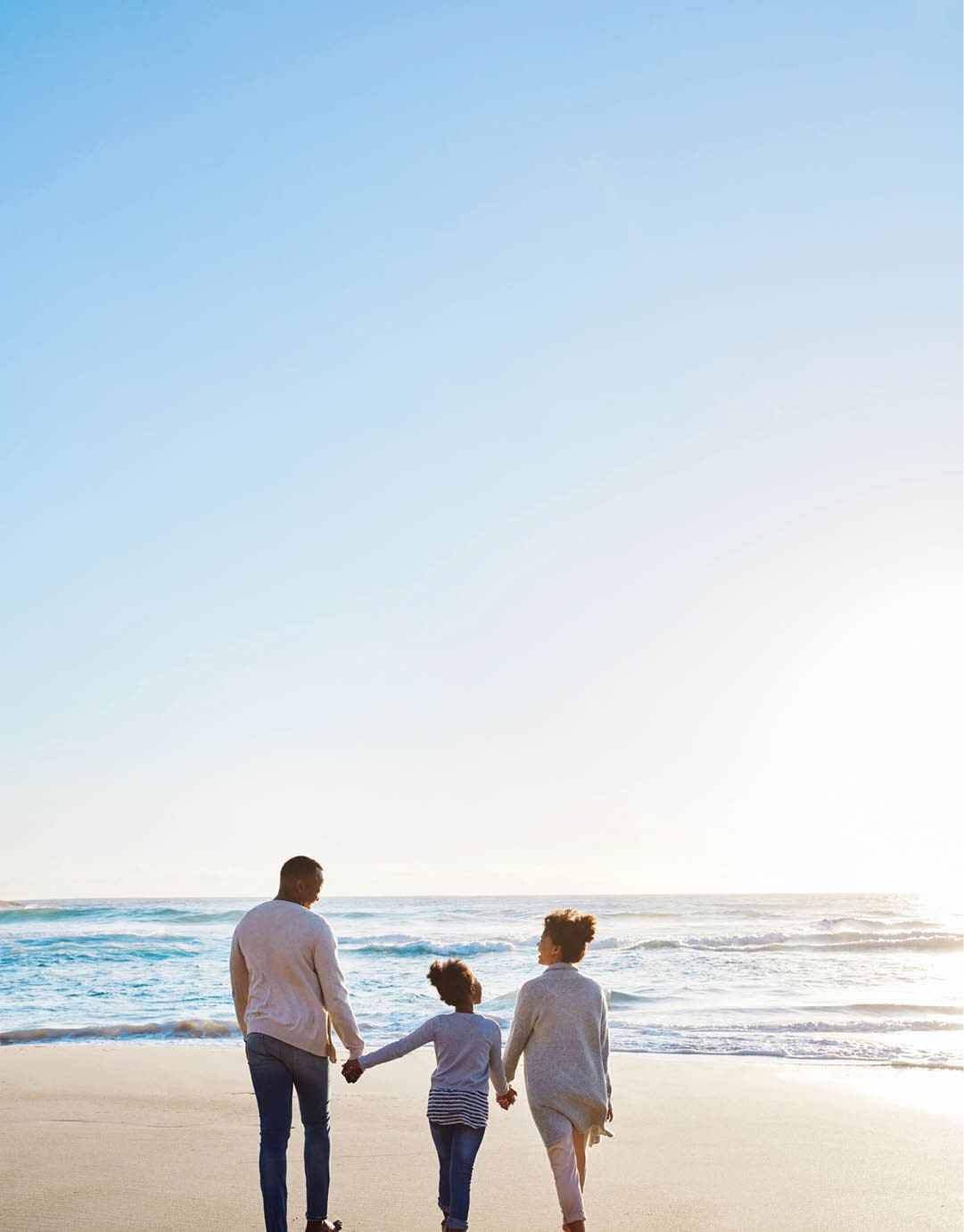 Shot of an adorable little girl going for a walk with her parents on the beach
