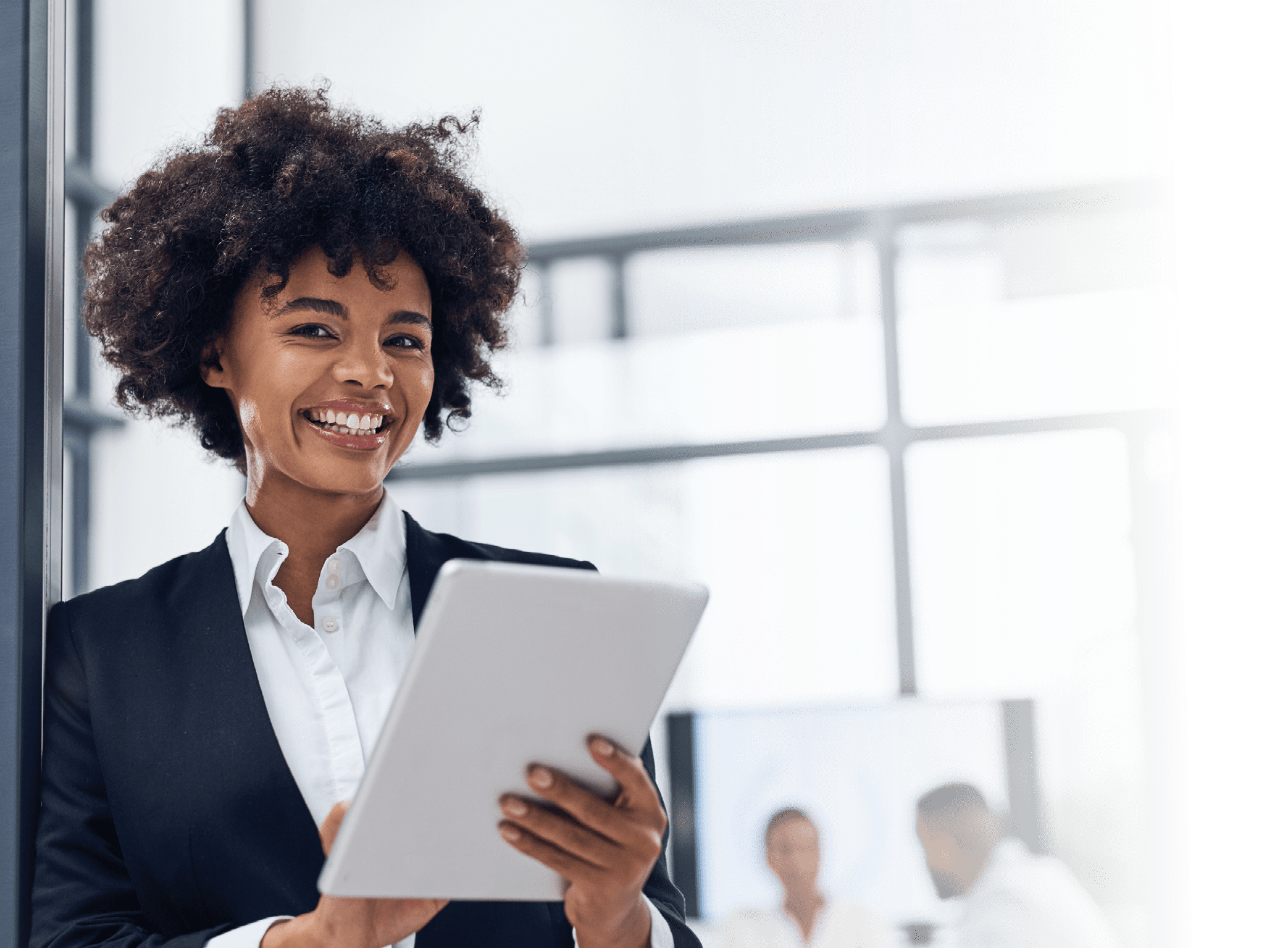 Shot of a young businesswoman using a digital tablet in a boardroom with her colleagues in the background